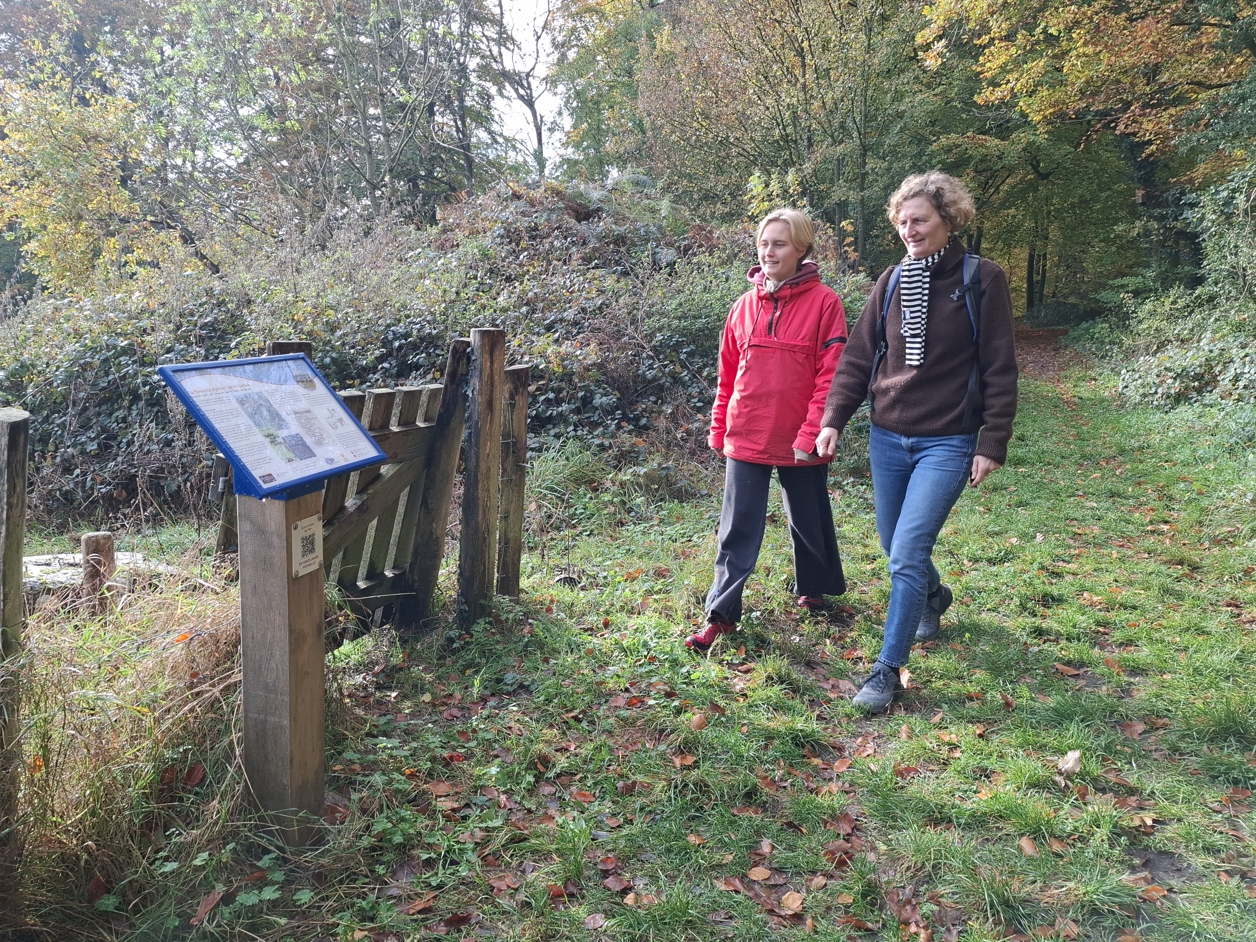 To kvinder læser skilt om vandrefortællinger langs Øhavsstien